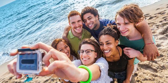 young people enjoying the beach stop to take a selfie
