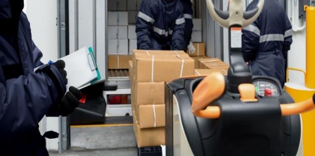 Image of workers picking up and loading cold chain boxes in storage center