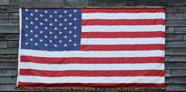 American Flag handing on side of wooden building
