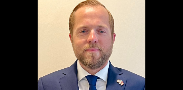 Man with a beard in a suit with a blue tie