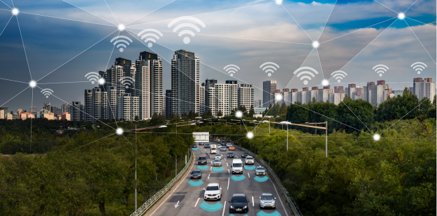 Cars on city highway with internet symbols above cars and buildings