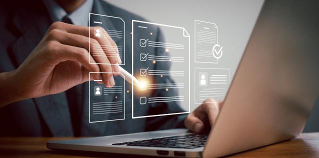 A hand checking off a virtual checklist above a laptop.