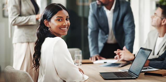 Happy business woman in office presenting data to team