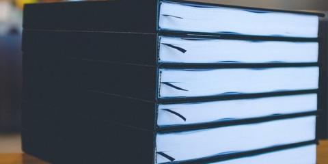 Blue hardbound books on wooden table