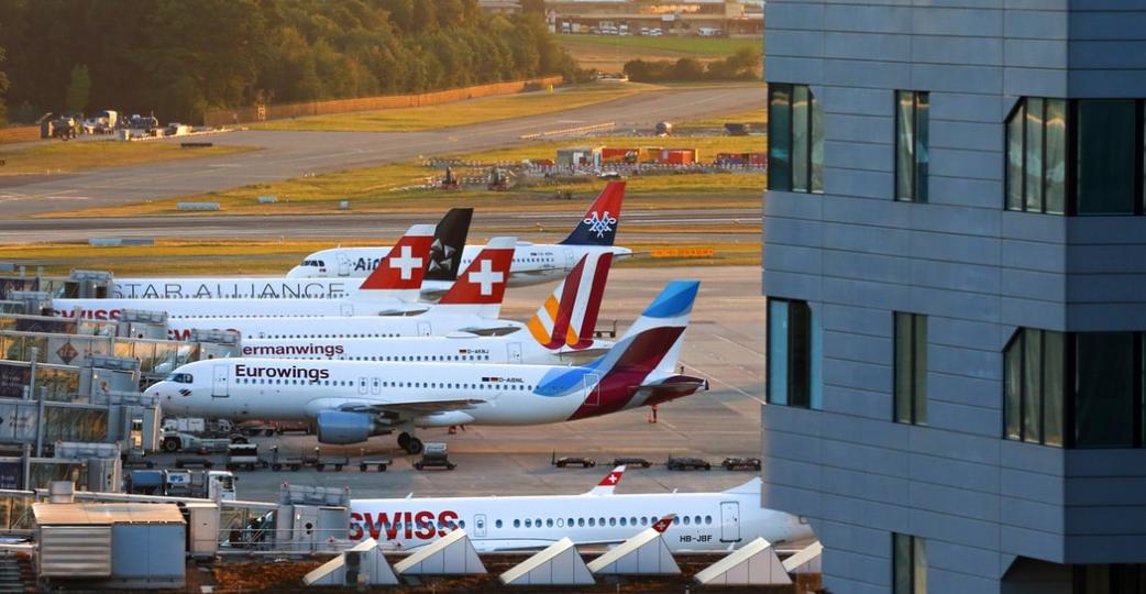 Different planes lined up at airport gates