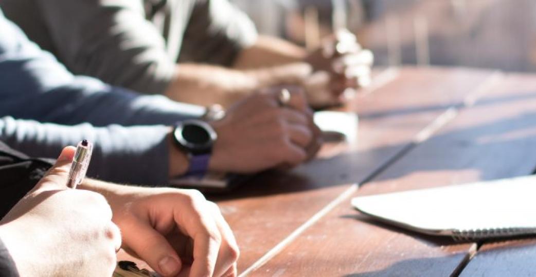 Group of People at a Meeting Table with Papers