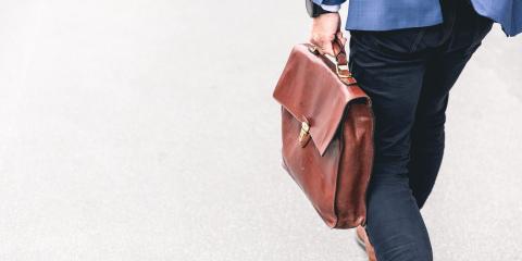 Guy in suit carrying a brown briefcase