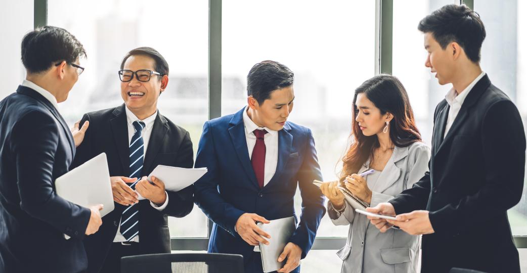 Five business people of Asian descent meeting