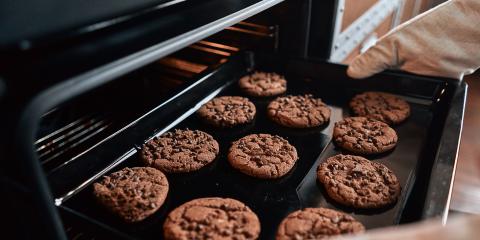 Chocolate cookies being taken out of the oven