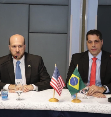 Representatives of U.S. and Brazil sitting at a table listening