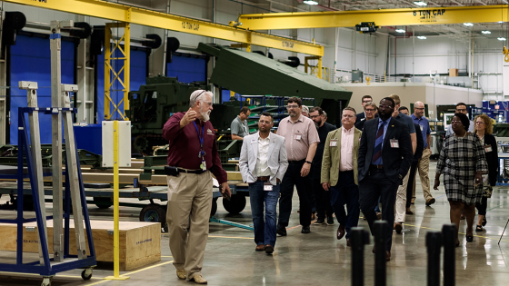 Group of people walking around in a factory
