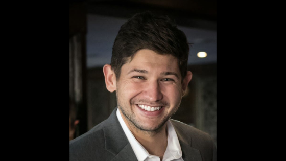 Man smiling wearing a white shirt and a suit