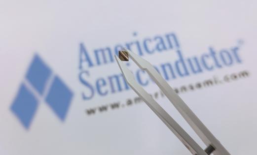 A semiconductor chip in front of the American Semiconductor logo which is blue