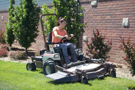 A woman mowing on a Grasshopper Mower