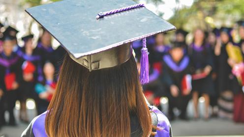 a woman with at cap and gown at a ceremony