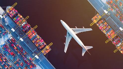A cargo plane flies over a shipping hub