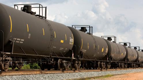 A line of connected black freight tanks for hauling liquid materials