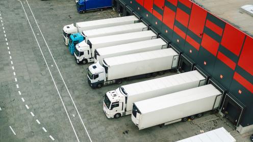 Semitrucks are backed into a distribution center for loading and offloading.